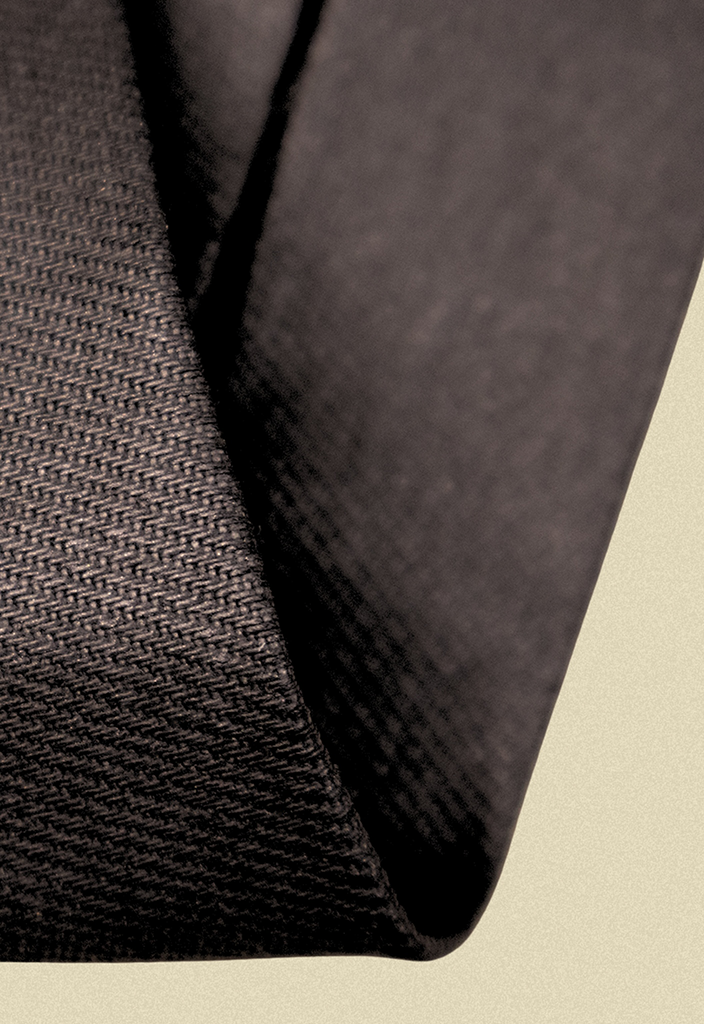 Repurposed coated black and army sateen tie on a beige background